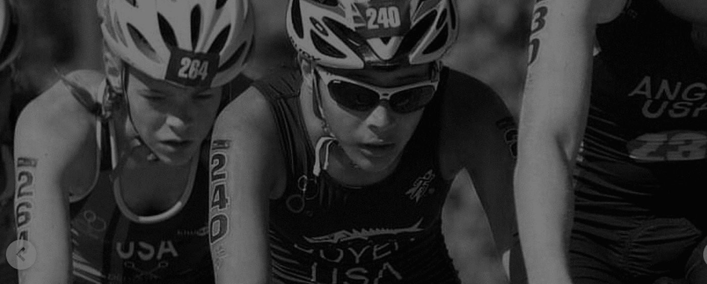 Focus on 2 youth triathlete racers on bikes in black and white